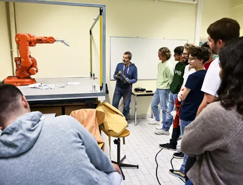 Des élèves et un enseignant devant une machine outil financé dans le cadre de la levée de fonds par des donateurs.