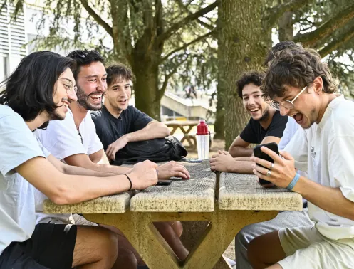 Des étudiants collaborent en plein air sur le Campus de Lyon-Ecully, travaillant sur un projet d'entrepreneuriat, probablement un WEEX. Dans le cadre de la campagne de levée de fonds, le mécénat et les dons soutiennent la pédagogie dédiée à l'entrepreneuriat à Centrale Lyon, en lien avec l'Axe 1 : Formation et Entrepreneuriat.